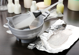 Miseczka z pędzelkiem do farbowania włosów i folia aluminiowa, symbolizujące specyficzne odpady generowane w branży beauty, objęte nowymi przepisami BDO.